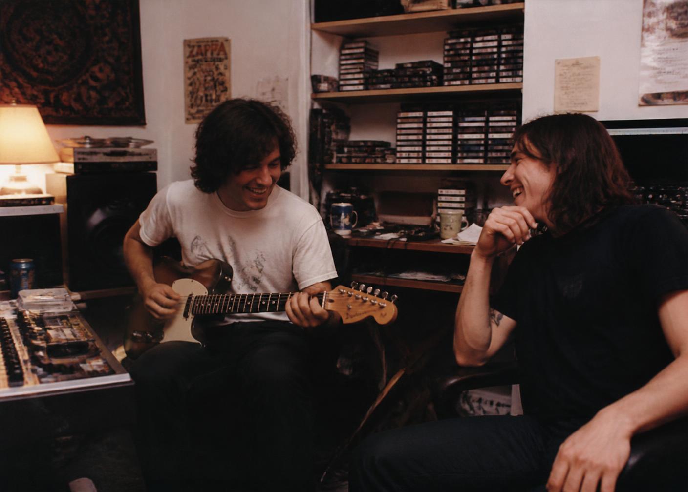 Two independent musicians playing together in a small home studio